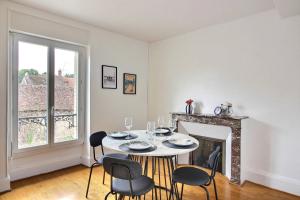 a dining room with a table and chairs and a fireplace at Le Franche in Châtillon-sur-Loire