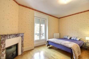 a bedroom with a bed and a fireplace at Le Franche in Châtillon-sur-Loire