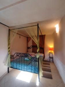 a bedroom with a canopy bed in a room at La Sorgente Apartment with private pool in Calice Ligure