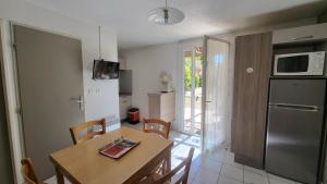 a kitchen and dining room with a table and a refrigerator at VVF Sigean Port-la-Nouvelle Corbières in Sigean