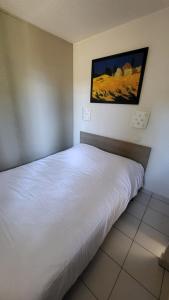 a white bed in a room with a picture on the wall at VVF Sigean Port-la-Nouvelle Corbières in Sigean +20 photos