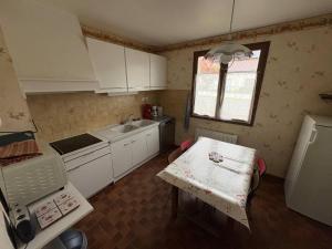 a small kitchen with a table and a sink at Le Petit Puits de l Ange in Bonny-sur-Loire