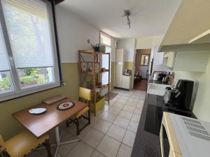 a kitchen with a wooden table and a tableasteryasteryasteryasteryasteryasteryastery at Le Petit Baron in Crémieu