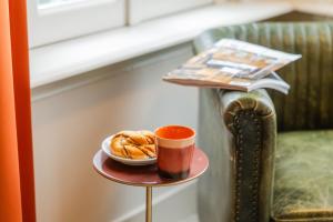 a table with a cup of coffee and a plate of pastries at Brass Hotel in Utrecht
