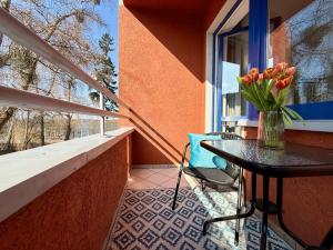 ein Balkon mit einem Tisch und einer Vase mit Tulpen in der Unterkunft Virta 8 in Ostróda