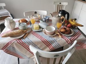 a breakfast table with breakfast foods and orange juice at La Maison d'Eana in Maintenon