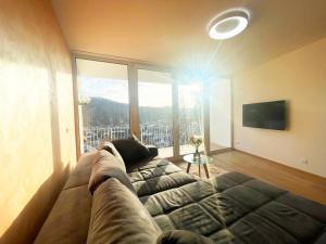 a living room with a couch and a large window at Schönes Apartment Traumblick mit Balkon Bad Ems in Bad Ems