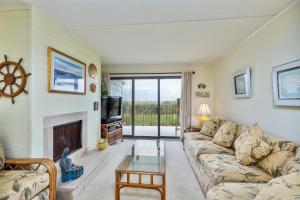 a living room with a couch and a fireplace at 5695 - Pelican's Perch in Nags Head