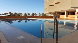 a swimming pool in front of a building at Apartamentos Chinasolymar in Almuñécar