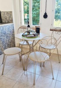 a white table and chairs with a wine bottle on it at La Chaumière in Salles-Lavalette