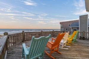 a row of chairs sitting on a deck overlooking the ocean at 5725 - A Dream Vacation in Nags Head +83 photos