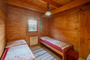 a bedroom with two beds in a wooden cabin at Hotel Ranč u Edyho in Námestovo
