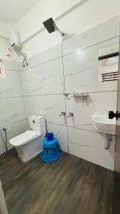 a white bathroom with a toilet and a sink at MIRACLE inn NEAR AL-AMEEN COLLEGE in Alwaye