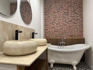a bathroom with a tub and a sink and a bath tub at La Forge 8 Personnes in Bèze +18 photos