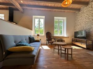 a living room with a couch and a tv at La Forge 8 Personnes in Bèze