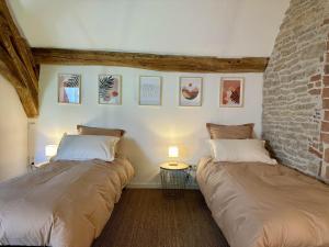 two beds sitting next to each other in a room at La Forge 8 Personnes in Bèze