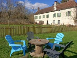 three chairs and a table in the yard of a house at La Forge 8 Personnes in Bèze