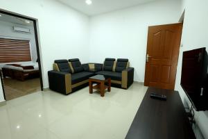 a living room with a couch and a table at Manna Residency in Kottayam