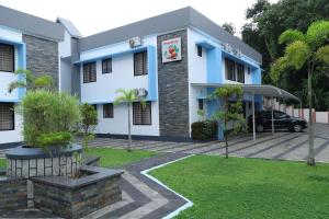 a building with a car parked in front of it at Manna Residency in Kottayam