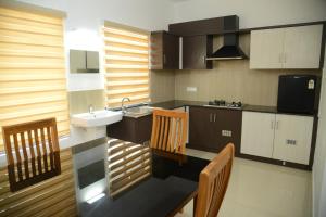 a kitchen with a sink and a counter top at Manna Residency in Kottayam