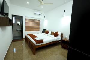 a bedroom with a bed and a toilet in it at Manna Residency in Kottayam