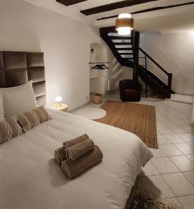 a bedroom with a white bed with a towel on it at Logement atypique en souplex in Sélestat