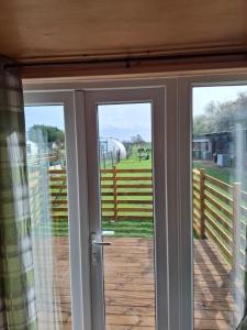 a sliding glass door with a view of a pasture at Mardi Gras, Upwell in Upwell