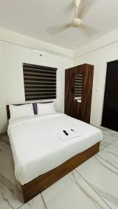 a bedroom with a large bed with a wooden headboard at MIRACLE inn NEAR AL-AMEEN COLLEGE in Alwaye