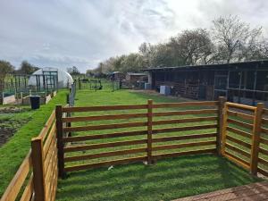 a fence in front of a field with a playground at Mardi Gras, Upwell in Upwell