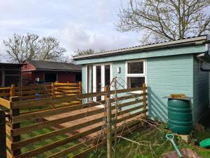 a house with a wooden fence next to it at Mardi Gras, Upwell in Upwell +32 photos