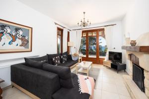 a living room with a couch and a fireplace at Villa Ariadne in Argaka