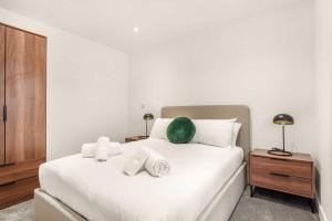 a bedroom with a white bed with a green pillow on it at Stylish 1 BED Apartment in Central Hull in Hull