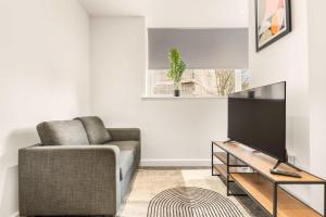 a living room with a couch and a flat screen tv at Stylish 1 BED Apartment in Central Hull in Hull