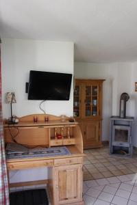 a living room with a television on a wooden desk at Ferienhaus Alpkönigin in Missen-Wilhams +7 photos