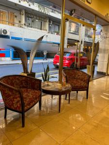 two chairs and a table in front of a train at Hotel Europa in Buenos Aires
