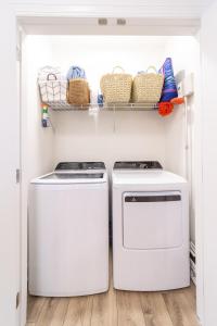 two washing machines sitting next to each other in a closet at Palmetto Place, Charming Saint Simons Bungalow in Saint Simons Island