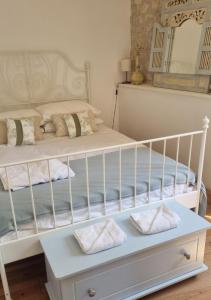 a bedroom with a white crib with pillows at La Chaumière in Salles-Lavalette +32 photos