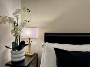 a vase with flowers on a table next to a bed at MILUAR Relais - Piazza Fuga in Naples