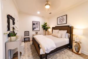 a bedroom with a bed and a dresser with a mirror at Palmetto Place, Charming Saint Simons Bungalow in Saint Simons Island