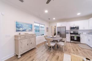 a kitchen with white cabinets and a table and chairs at Palmetto Place, Charming Saint Simons Bungalow in Saint Simons Island