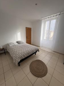 a bedroom with a bed and a rug on the floor at Le Mercoyrol in Cruas