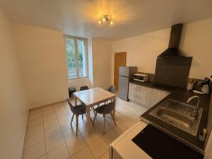 a kitchen with a table and a kitchen with a sink at Le Mercoyrol in Cruas