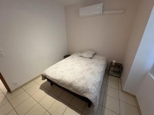 a small bedroom with a bed and a tiled floor at Le Mercoyrol in Cruas +6 photos