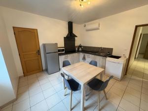 a kitchen with a table and chairs and a refrigerator at Le Mercoyrol in Cruas