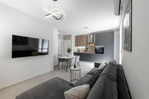 a living room with a couch and a kitchen at Cozy Corner 49 in Cavtat