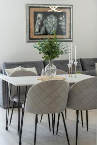 a dining room table with two chairs and a vase with flowers at Cozy Corner 49 in Cavtat