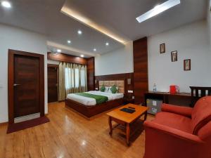 a hotel room with a bed and a red couch at Hotel Dewan Palace in Dharmsāla