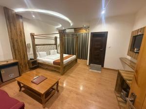 a room with a bed and a table in a room at Hotel Dewan Palace in Dharmsāla