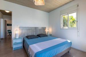 a bedroom with a blue bed and a window at L' Amandava in Petite Île +14 photos