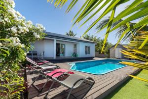 a deck with lounge chairs and a swimming pool at L' Amandava in Petite Île